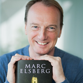 Marc Elsberg hält seinen Romans „Blackout“ lächelnd in die Kamera.