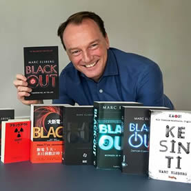 Marc Elsberg präsentiert lächelnd alle seine Romane.