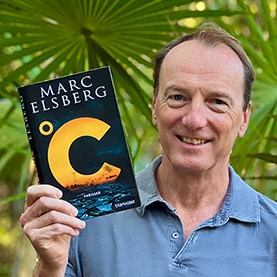 Marc Elsberg präsentiert seinen Roman Celsius, hält das Buch vor einer Palme in die Kamera.